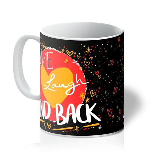 White mug with art print. ‘live laugh land back’ written in white with a yellow heart and red circle behind. The background is black with small dots, squiggles, stars and hearts dotted around the image in red, yellow and white. Handle is on the left.
