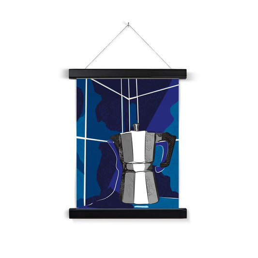A black wooden poster hanger. The print: A grey moka pot is sitting on a bench and it is rendered in grey/black/white with doodle accents. The background is in blues, with white lines that indicate they are tiles, and squiggle accents.