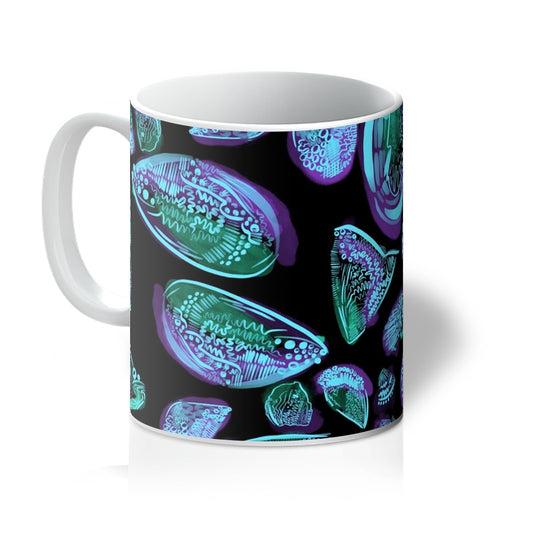 A white mug printed with art. An abstract drawing of sea shells arranged in a circle. The background is black and the design is sea shells rendered with dark green/purple wash and light blue line markings. Handle is on the left. 