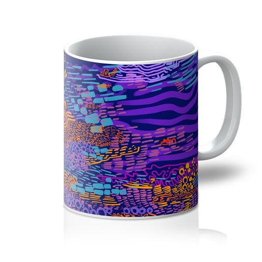 White mug with art print. An abstract drawing of a tree. It uses circles, squiggles and lines. The background is plain purple and the doodles are in lavender, orange, hot pink and light blue. Handle is on the right. 