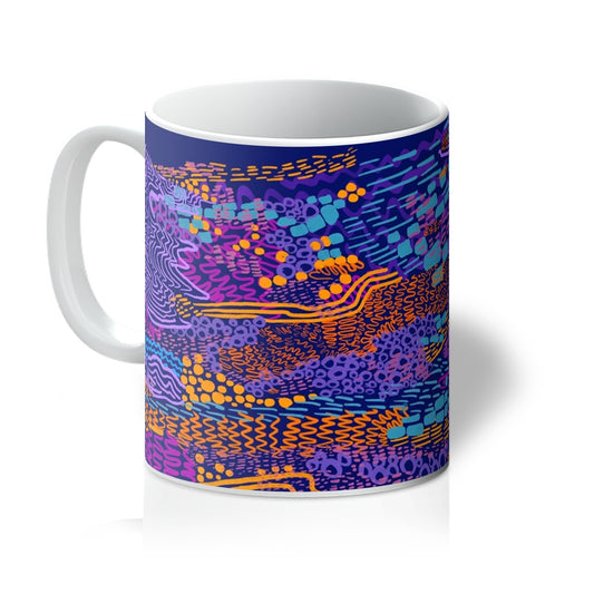 White mug with art print. An abstract drawing of a tree. It uses circles, squiggles and lines. The background is plain purple and the doodles are in lavender, orange, hot pink and light blue. Handle is on the left.