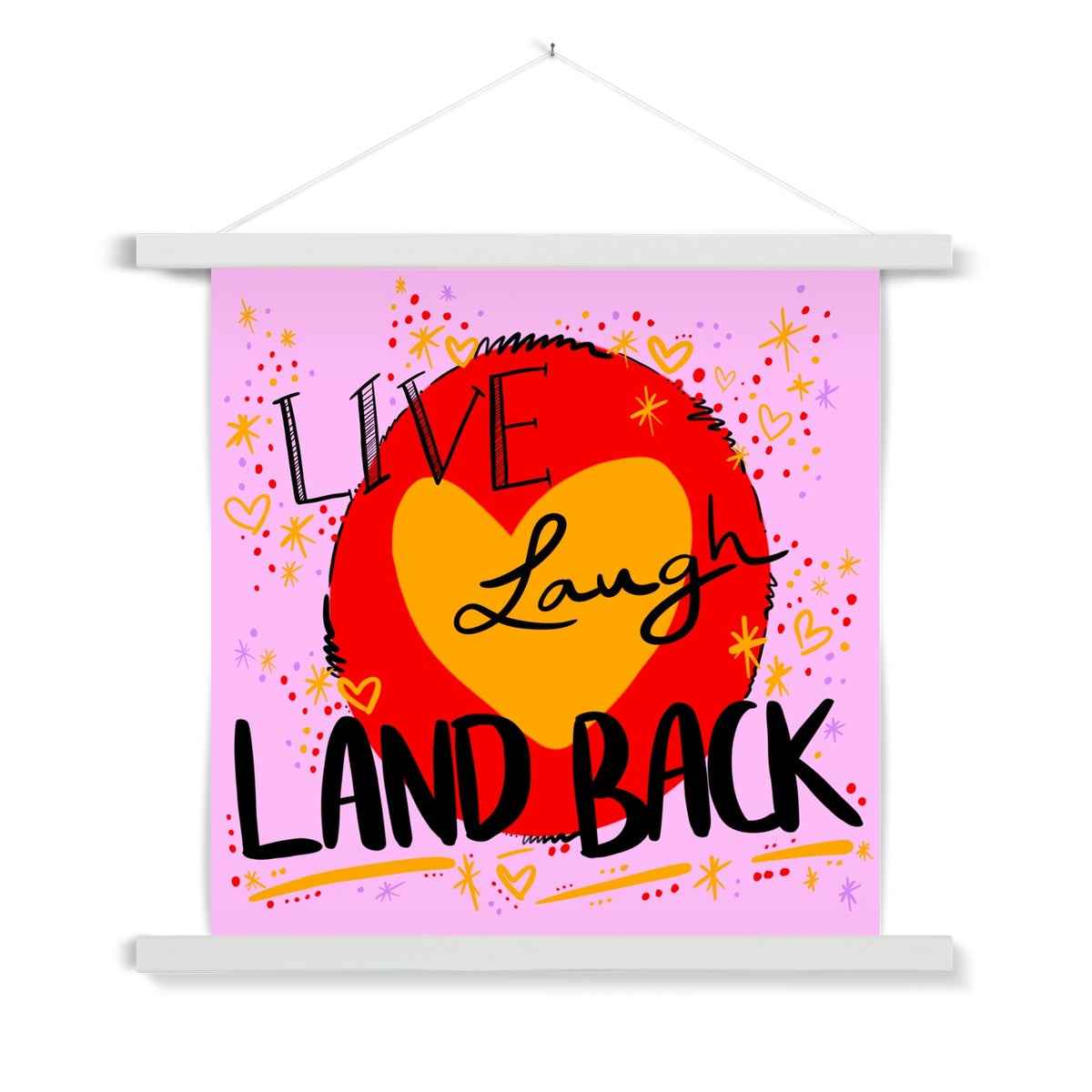 White wooden poster hanger. The art print is square. The design: ‘live laugh land back’ written in black with a yellow heart and red circle behind. The background is pink with small dots, squiggles, stars and hearts dotted around the image in red, yellow and purple.