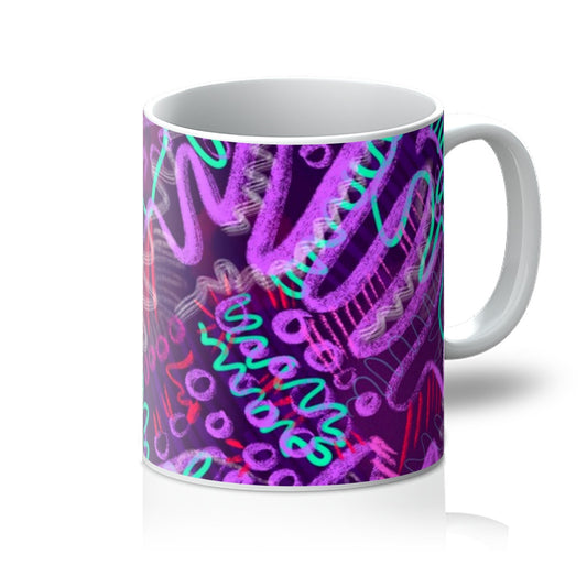 A white mug printed with art. The abstract design has aqua green squiggles, light and dark purple squiggles and circles and hot pink lines. Handle is on the right. 