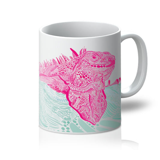 White mug with art print. design is an Iguana laying on top of a branch. They are both rendered in lines, squiggles and circles. The Iguana is mid pink and the branch is jade green. The Iguana’s face in the in the centre and the handle is to the right.