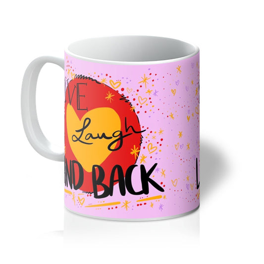 White mug printed with art. ‘live laugh land back’ written in black with a yellow heart and red circle behind. The background is pink with small dots, squiggles, stars and hearts dotted around the image in red, yellow and purple. Handle is on the left. 